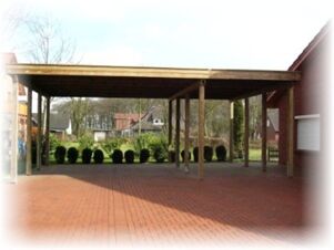 ホテル＆アパルトマン クロステルマン（Hotel & Appartements Klostermann）の、木製の支柱と舗装された床で覆われた屋外エリア。