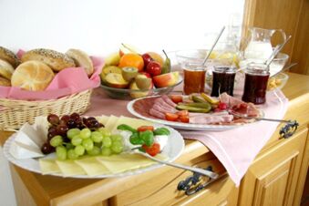 Petit d&eacute;jeuner buffet avec des fruits frais, du pain, du fromage, de la charcuterie et de la confiture &agrave; la pension Garni Zweck, soigneusement pr&eacute;sent&eacute;.