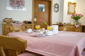 Salle de petit-d&eacute;jeuner agr&eacute;able avec table dress&eacute;e et arrangement floral dans la pension Garni Zweck, id&eacute;ale pour commencer le petit-d&eacute;jeuner en toute d&eacute;contraction.