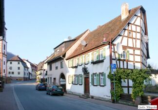 Fachwerkhaus an einer ruhigen Stra&szlig;e mit gr&uuml;nem Fensterladen und einem roten Dach, typisch f&uuml;r Elke's Landgasthof Zum Anker Partyservice Elke Bauer.