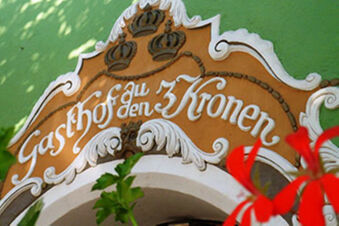 Geleneksel tarzdaki Hotel-Caf&eacute; 3 Kronen'in Gasthof zu den 3 Kronen yazılı s&uuml;sl&uuml; girişine yakın &ccedil;ekim.