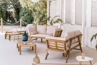Outdoor seating area with wooden furniture, beige cushions, a small white table with drinks, and greenery at B&B Hotel Mantova Cristallo