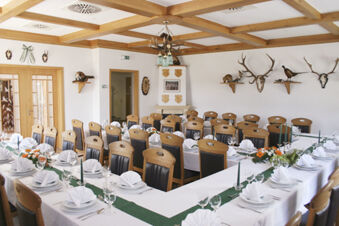 Dining room at Land-gut-Hotel Seeblick with arranged tables, wooden chairs, mounted animal heads, and a wooden ceiling grid