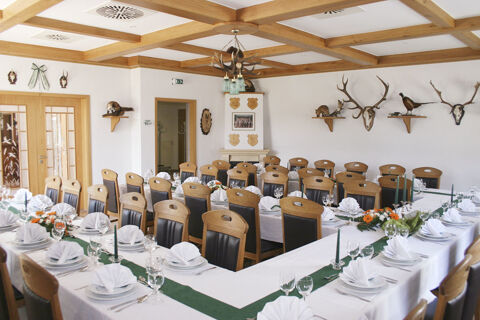 Dining room at Land-gut-Hotel Seeblick with arranged tables, wooden chairs, mounted animal heads, and a wooden ceiling grid
