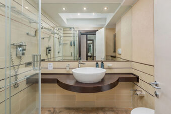 Bathroom at B&B Hotel San Mauro featuring round white sink on dark wooden countertop and large wall mirror
