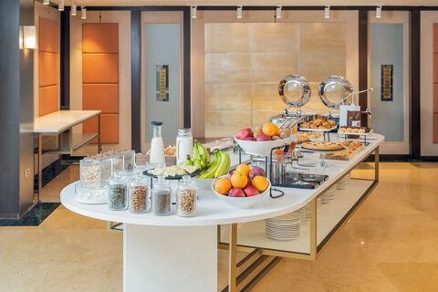 Breakfast buffet with fruits, nuts, cereals, milk, pastries, and juice dispensers at B&B Hotel San Mauro