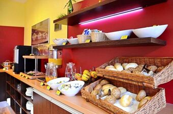 Breakfast buffet with baskets of assorted bread rolls, bowls of fruit and condiments, and juice dispensers at Hotel G&auml;stehaus Centro Albert GmbH
