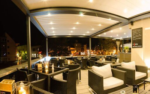陶尔米纳酒店（Hotel Taormina）的室外露台舒适宜人、灯火通明，配有藤制家具和桌子，是晚上休闲放松的理想场所。
