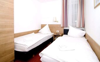 位于陶尔米纳酒店（Hotel Taormina）内的小卧室，布置明亮，配有两张单人床、床头柜和窗户。