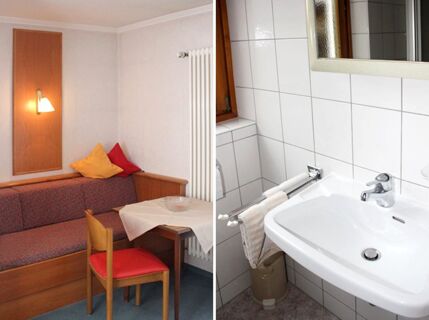 Living area with a wooden sofa and table with tablecloth next to a bathroom with white tiled walls at Pension Graml Fr&uuml;hst&uuml;ckspension