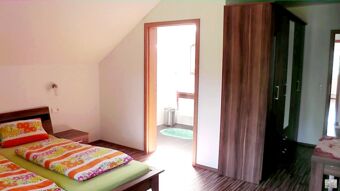Twin beds with colorful bedding and wooden furniture in a bright room at Hotel Restaurant Pension Weiherm&uuml;hle