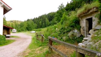 Maal&auml;hedane &uuml;mbrus koos metsa, heinamaa ja teega hotelli-restorani Pension Weiherm&uuml;hle k&otilde;rval, kus on parkla ja majad.