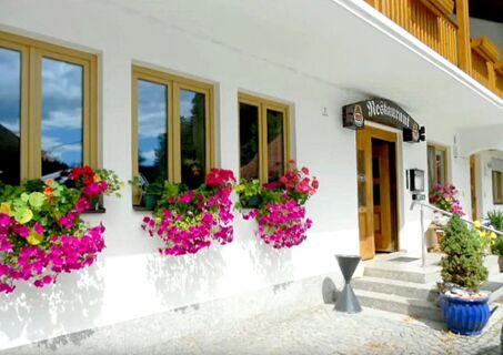 Exterior view of Hotel Restaurant Pension Weiherm&uuml;hle with flower boxes under windows and entrance stairs with plants visible