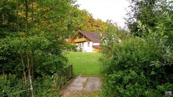 Vaade puude ja heinamaaga rohelisele v&auml;litingimustele hotelli restoranipansion Weiherm&uuml;hle hoonele vaiksel loodusmaastikul.