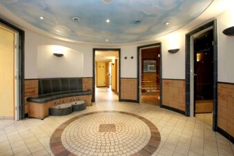 Curved bench with footbaths inside a tiled circular floor room with three doorways at Landgasthof Hirsch Dapfen