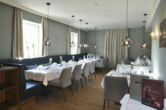 Modern eingerichteter Restaurantbereich mit gedeckten Tischen und stilvollen Lampen im Hotel Restaurant Klosterhof GmbH f&uuml;r feierliche Anl&auml;sse und G&auml;ste.
