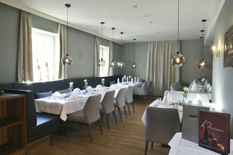 Modern eingerichteter Restaurantbereich mit gedeckten Tischen und stilvollen Lampen im Hotel Restaurant Klosterhof GmbH f&uuml;r feierliche Anl&auml;sse und G&auml;ste.
