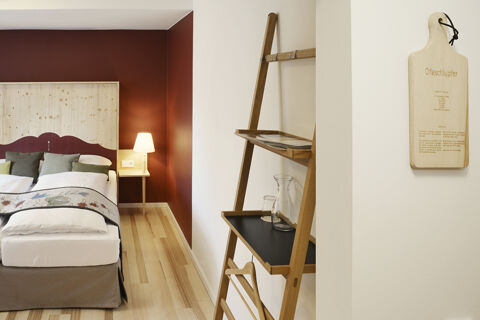 Modern eingerichtetes Hotelzimmer mit Holzakzenten, warmen Farbt&ouml;nen und dekorativen Kissen im Hotel Restaurant Klosterhof GmbH.