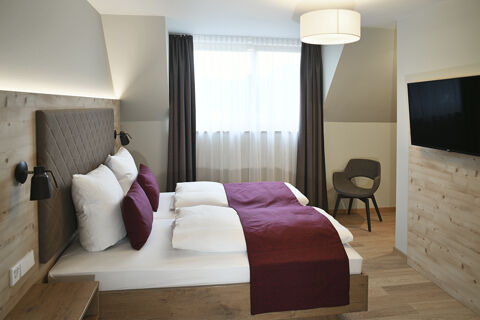 Modern eingerichtetes Hotelzimmer mit zwei gem&uuml;tlichen Betten und dunkellila Dekoration im Hotel Restaurant Klosterhof GmbH.
