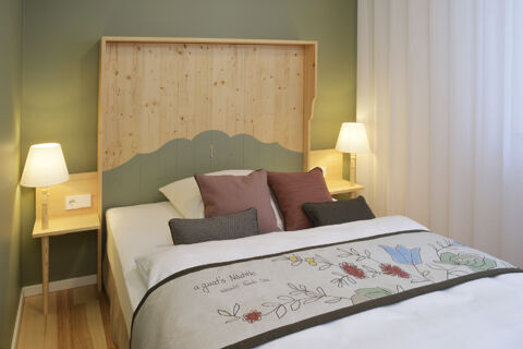 Gem&uuml;tliches Hotelzimmer mit Holzbetthaupt, dekorativen Kissen und Lampen, stimmig eingerichtet im Hotel Restaurant Klosterhof GmbH.