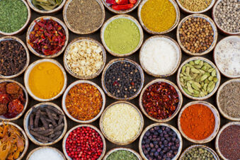 Various colorful spices and herbs arranged in small ceramic bowls on a wooden surface at Lodner&acute;s Genie&szlig;erhotel & Hotel Drei Mohren