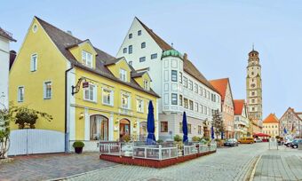 Street view of historic European buildings with outdoor dining and cobblestone road at Lodner&acute;s Genie&szlig;erhotel & Hotel Drei Mohren
