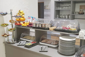 Buffet con frutta fresca, salumi, yogurt e dolci nell'area colazione dell'Hotel Garni Metzingen per gli ospiti.