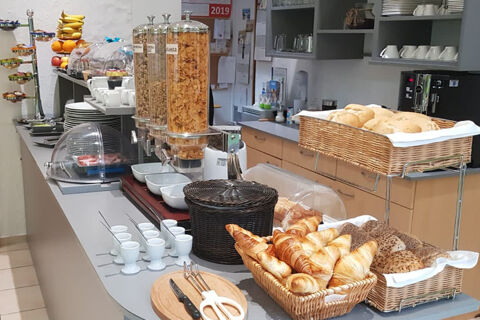 Raňajkov&yacute; bufet s r&ocirc;znymi rožkami, croissantmi, cere&aacute;liami a poh&aacute;rmi je pripraven&yacute; pri dlhom pulte v hoteli Garni Metzingen.