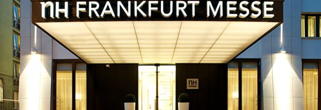 Entrance of NH Hotel Frankfurt Messe with illuminated signage and large glass doors in a modern building facade
