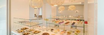 Buffet display with various pastries, fruits, and desserts in a modern white dining area at NH Collection Roma Palazzo Cinquecento