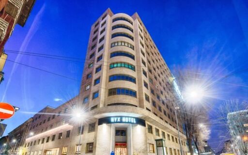 NYX Hotel Milan exterior view at dusk with illuminated entrance and multiple windows on a multi-story building