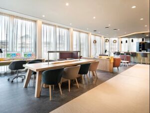Heller und moderner Lobbybereich im Holiday Inn Mannheim City - Hauptbahnhof mit Sitzpl&auml;tzen, Arbeitspl&auml;tzen und gro&szlig;en Fenstern mit Vorh&auml;ngen.