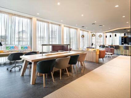 Heller und moderner Lobbybereich im Holiday Inn Mannheim City - Hauptbahnhof mit Sitzpl&auml;tzen, Arbeitspl&auml;tzen und gro&szlig;en Fenstern mit Vorh&auml;ngen.