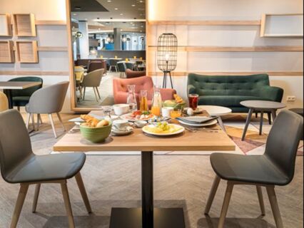 Fr&uuml;hst&uuml;ckstisch mit verschiedenen Speisen und Getr&auml;nken in einem modernen Restaurant des Holiday Inn Mannheim City - Hauptbahnhof.