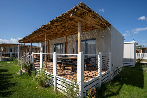 Outdoor wooden deck with chairs and table under a wooden pergola at Milano Marittima Boutique Resort on a sunny day