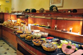 Buffet spread with assorted breads, cold cuts, fruit salad, cereals, jams, and dairy products at Akzent Hotel Stadt Schl&uuml;chtern