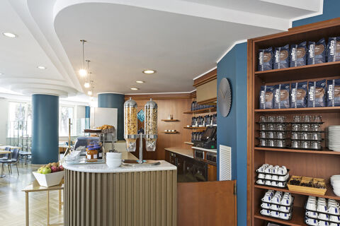 Breakfast area at B&B Hotel Pescara showing cereal dispensers, jars, bowls, coffee cups, plates, and shelves with Lavazza coffee packages