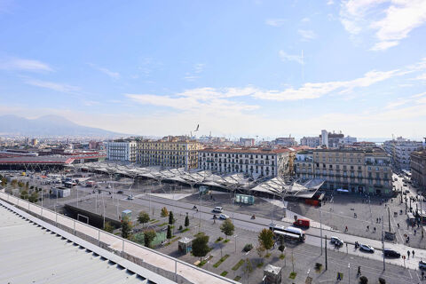 View of Piazza Garibaldi with buses, cars, people, and buildings under a partly cloudy sky at B&B Hotel Napoli