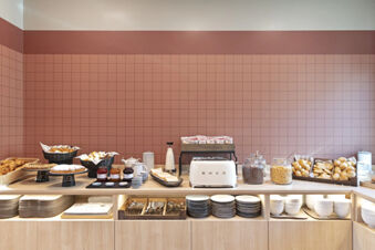 Breakfast buffet with bread, pastries, jars of cereals, toaster, milk, jam, plates and cutlery at B&B Hotel Roma Fiumicino Aeroporto Fiera