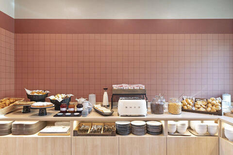 Breakfast buffet with bread, pastries, jars of cereals, toaster, milk, jam, plates and cutlery at B&B Hotel Roma Fiumicino Aeroporto Fiera