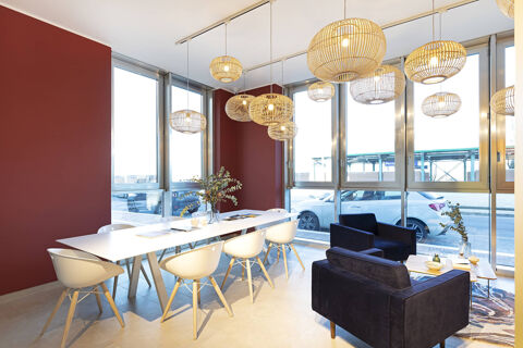 Bright meeting room at B&B Hotel Roma Fiumicino Aeroporto Fiera with white chairs around a table and black armchairs near windows