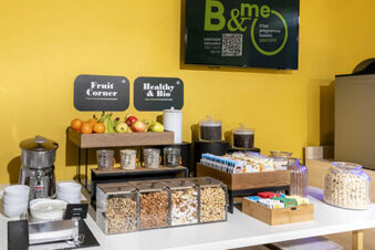 Breakfast buffet table at B&B Hotel Roma San Lorenzo Termini with fresh fruit, nuts, cereals, yogurt, and various packaged snacks