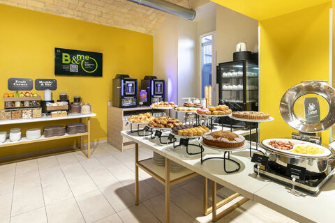 Breakfast buffet with pastries, cakes, scrambled eggs, sausages, cereal, fruits, and coffee machines at B&B Hotel Roma San Lorenzo Termini