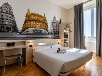Bedroom interior of B&B Hotel Genova Principe featuring a double bed, desk with chair, open wardrobe, and large wall mural with buildings and fountain