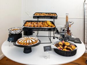 Assorted pastries including croissants, donuts, and cake slices arranged in baskets on a table at B&B Hotel Genova Principe