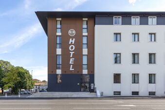 Exterior view of B&B Hotel Brescia showing the modern brown and white building facade with multiple windows and hotel signage