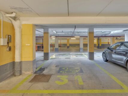Empty parking space numbered 31 with electric vehicle charging markings inside B&B Hotel Cremona garage with a car parked nearby