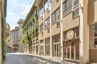 Street view of beige modern building with large windows and B&B Hotel Milano City Center Duomo sign on the facade