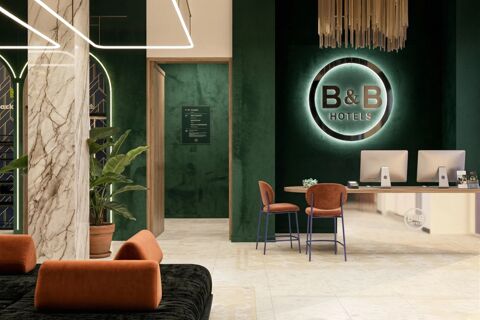 Lobby interior of B&B Hotel Milano Duomo Velasca with green walls, illuminated hotel logo, wooden desk, and orange chairs