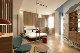 Modern hotel room with bed, wooden panels, blue chair, hanging TV, and champagne setup at B&B Hotel Milano Duomo Velasca